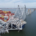 An image showing the collapsed Key Bridge in Baltimore, with a container ship lodged in its suspension cables.